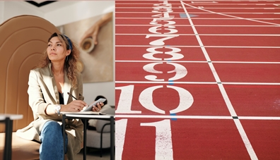 A woman sitting down in thought next to a starting line. Business development coaching
