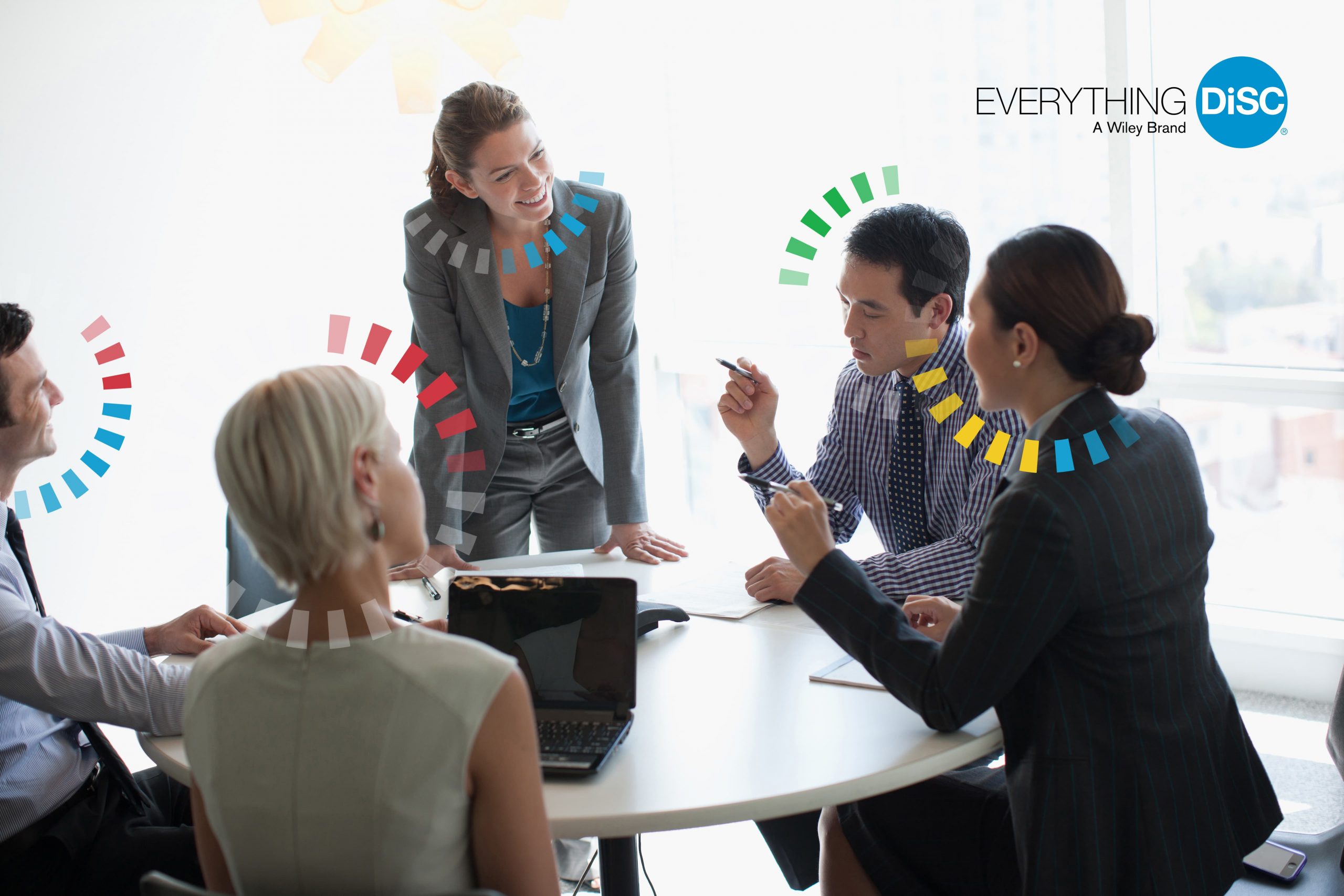 Everything DiSC Image-004 Four people around a table in a meeting.